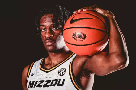 sean east holds mizzou basketball on his shoulder