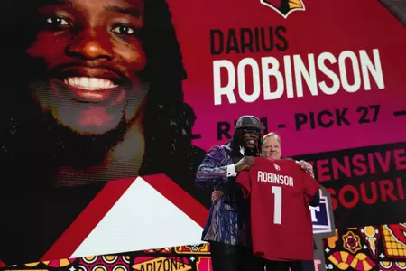 Missouri defensive lineman Darius Robinson, left, poses with NFL Commissioner Roger Goodell after being chosen by the Arizona Cardinals with the 27th overall pick during the first round of the NFL football draft, Thursday, April 25, 2024, in Detroit. (AP Photo/Jeff Roberson)