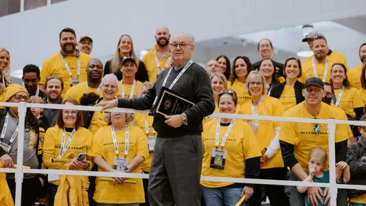 Former Mizzou Track and field head coach Dr. Rick McGuire posing with his former letterwinners after being honored at the Dr. Rick McGuire Invitational on Feb. 1, 2025