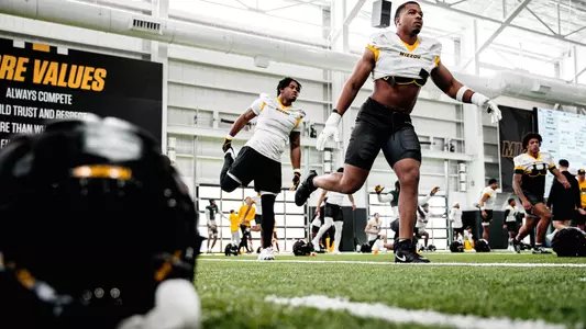 Josiah Trotter and Mikai Gbayor duing spring practice warmups