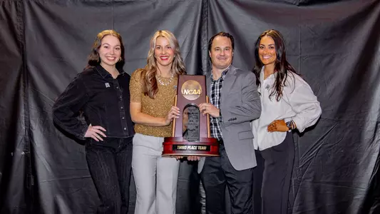 Head coach of Missouri gymnastics Shannon Welker and assistant coaches Whitney Snowden, Lacey Rubin and Jackie Terpak pose with the team's NCAA Gymnastics third place trophy following the team's meet on April 19, 2025 at Dickies Arena.