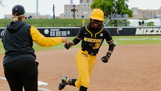 Head coach Larissa Anderson high fives Saniya Hill as she rounds the bases for her first career home run