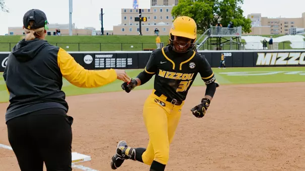 Head coach Larissa Anderson high fives Saniya Hill as she rounds the bases for her first career home run