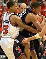 Northwestern's Tavaras Hardy wrestles the ball away from Illinois' Cory Bradford.