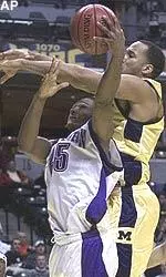 Jitim Young gets fouled by Michigan's Leon Jones on his way to the basket in the first round game of the Big 12 Conference tournament.