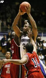 Mike Thompson splits Delaware State defenders Troy Roundtree, left, and Bruce Davis (11) on his way to the hoop to score in the second half.