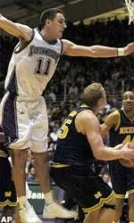 Vedran Vukusic leaps into the air to defend against a shot by Michigan's Graham Brown.