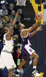 Northwestern guard Sterling Williams, right, takes a shot under the basket against Michigan's Lester Abram, left, in the first half. (AP Photo/Duane Burleson)