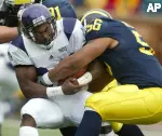 Terrell Jordan is stopped by Michigan's LaMarr Woodley during the first quarter Saturday in Ann Arbor.
