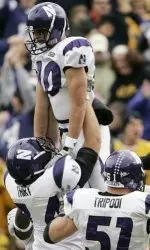 Northwestern's Eric Peterman, top, celebrates with teammates Dylan Thiry, left, and Joe Tripodi after scoring a touchdown during the first half. (AP Photo/Charlie Neibergall)