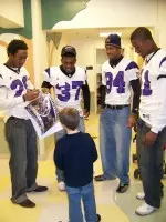 Thompson, Davie, Dockery and Vaughn sign autographs for a fan at Children's Memorial Hospital.