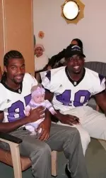 Northwestern football players Tonjua Jones and Eddie Simpson spend time with a new friend at CMH.
