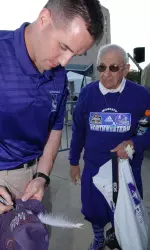 Head coach Pat Fitzgerald signs autographs at Saturday's Meet the Team night.