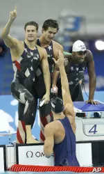 Members of the U.S. 4x100-meter freestyle relay preliminary squad help Matt Grevers out of the water following the team's world-record swim Sunday night in Beijing.