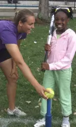 Junior pitcher Lauren Delaney serves up a ball on a tee for a member of the Girls in the Game.