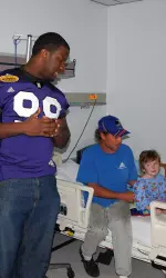 Corbin Bryant chats with a young patient and his father at St. Joseph's Children's Hospital.