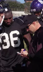 Coach Bates meeting with his linebackers during NU's bowl practice in San Antonio last December.