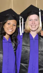 Women's soccer grads Ali Rubnitz (left) and Alicia Herczeg at commencement ceremonies Friday.