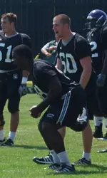 Corbin Bryant (98) and Jake Gregus (60) cheer on the defensive line during drills Thursday.