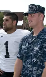 Stefan Demos visits with a sailor on the sideline of Monday's practice at the Naval Station Great Lakes.