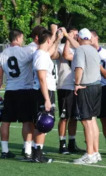 Northwestern's superbacks huddle with position coach Bob Heffner after NU's first practice of the 2010 season.