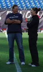 Kelly Amonte Hiller chats with Patriots head coach Bill Belichick Friday during NU's practice at Gillette Stadium.