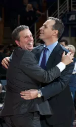 Assistant coach Brian James and head coach Chris Collins embrace following the Wildcats' victory.