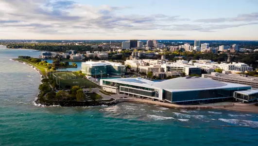 An aerial view of Walter Athletics Center from a drone flying over Lake Michigan to the northeast