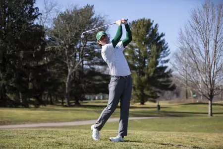 men's golf player takes swing