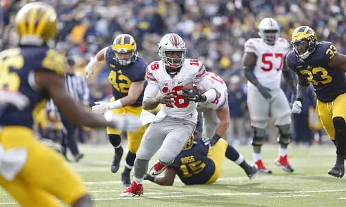 Ohio State Buckeyes quarterback J.T. Barrett (16) leaves a wake of Michigan players as he heads to the end zone at Michigan Stadium on November 28, 2015. (Chris Russell/Dispatch Photo)