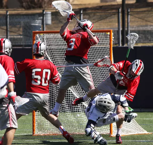 Ohio State goalkeeper Tom Carey (3) deflects a shot as Robby Haus (50) and Brendan Barger (45) also defend against Penn State on March 29, 2015. No. 16 Ohio State defeated unranked Penn State10-8 in their inaugural Big Ten Conference men's lacrosse game for both schools. Photo/© 2015 Craig Houtz