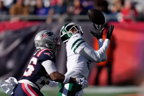 New York Jets wide receiver Garrett Wilson (5) reaches for the ball as New England Patriots cornerback Marcus Jones (25) defends in the second half of an NFL football game, Sunday, Oct. 27, 2024, in Foxborough, Mass. (AP Photo/Charles Krupa)