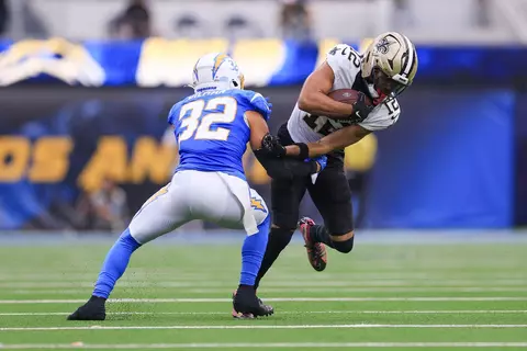 New Orleans Saints wide receiver Chris Olave (12) carries against Los Angeles Chargers safety Alohi Gilman (32) in the second half of an NFL football game in Inglewood, Calif., Sunday, Oct. 27, 2024. (AP Photo/Ryan Sun)