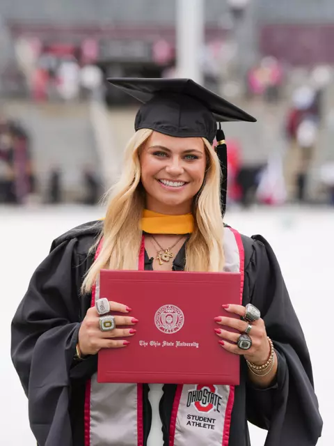 OSU Graduation graduate holding her diploma