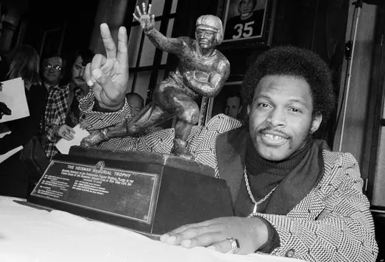 In this Dec. 2, 1975 Ohio State's running back Archie Griffin smiles and holds up two fingers as he poses with the 1975 Heisman Trophy in New York City. Griffin also won the Heisman in 1974. Griffin, the only two-time winner of the Heisman Trophy, says he'd welcome being joined in that elite company by Florida's Tim Tebow or Oklahoma's Sam Bradford. Tebow won the award two years ago as a sophomore and is quarterbacking the nation's No. 1-ranked team. Bradford, who won the Heisman last December as a sophomore, returned as quarterback for the Sooners, who are ranked No. 3. (AP Photo)