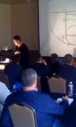 Coach Travis Ford goes over plays during a chalk talk session at his Coaches Clinic.