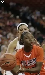 Andrea Riley, front left, passes around the defense by Texas guard Erika Arriaran, back left, and guard Yvonne Anderson, right, during first-half action.