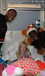 Cowboys Brian Williams (left) and Jean-Paul Olukemi visit with a patient at the OU Children's Hospital.