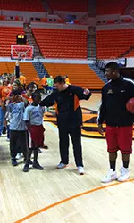 Coach Travis Ford and freshman Marcus Smart show some Special Olympians the fundamentals of basketball.