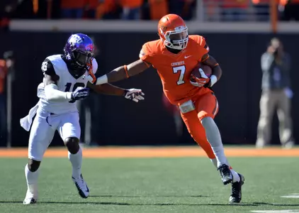 Oct 19, 2013; Stillwater, OK, USA; Oklahoma State Cowboys wide receiver Brandon Sheperd (7) retunes a kick-off against Texas Christian Horned Frogs defender Keivon Gamble (16) during the second half at Boone Pickens Stadium. Oklahoma State won 24-10. Mandatory Credit: Peter G. Aiken-USA TODAY Sports