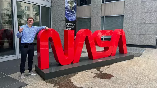 Carson Sager poses next to the NASA sign