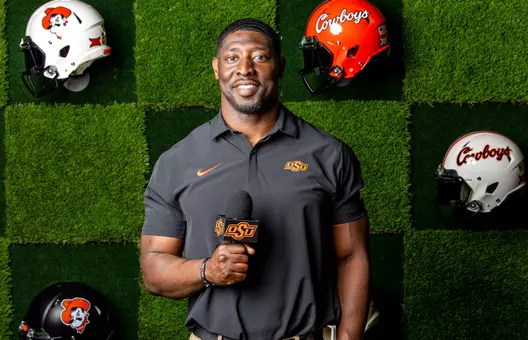 Deion Imade with a mic in front of an OSU backdrop.