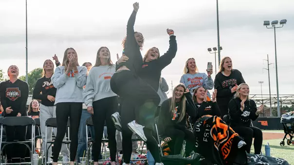 Members of the Oklahoma State softball team react to being selected to host a 2026 NCAA Regional.