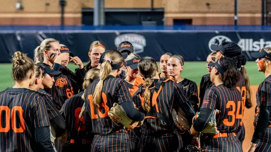 The Oklahoma State softball team gathers during its Big 12 Tournament semifinal game against Arizona State.