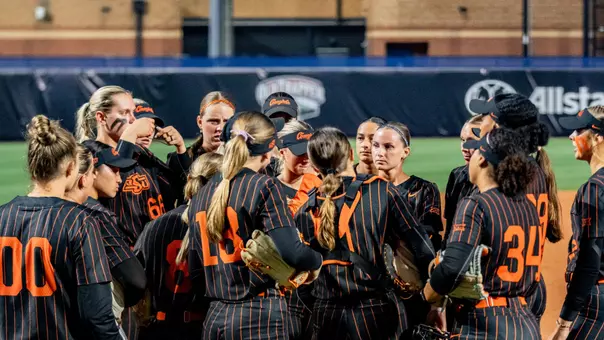 The Oklahoma State softball team gathers during its Big 12 Tournament semifinal game against Arizona State.