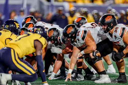 A photo of the line of scrimmage just before the snap in a football game played between Oklahoma State and West Virginia.