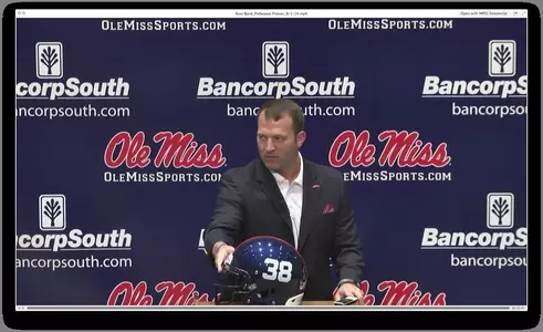 Ross Bjork shows off the 38 helmet that the team will wear for this year's Memphis game.