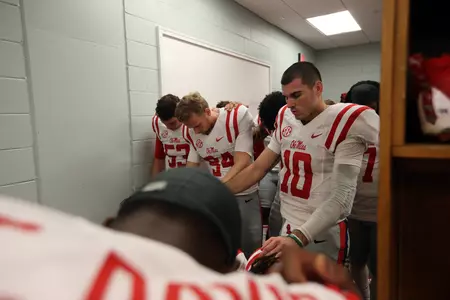 Chad Kelly prays with teammates in the locker room before the 2015 Egg Bowl. (photo by Joshua McCoy)