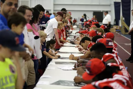 Football players sign autographs at 2014 Meet the Rebels Day. (photo by Joshua McCoy)