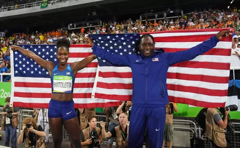 Gold medalist Tianna Bartoletta and silver medalist Brittney Reese pose with the American flag. (photo by Kirby Lee, USA Today Sports)